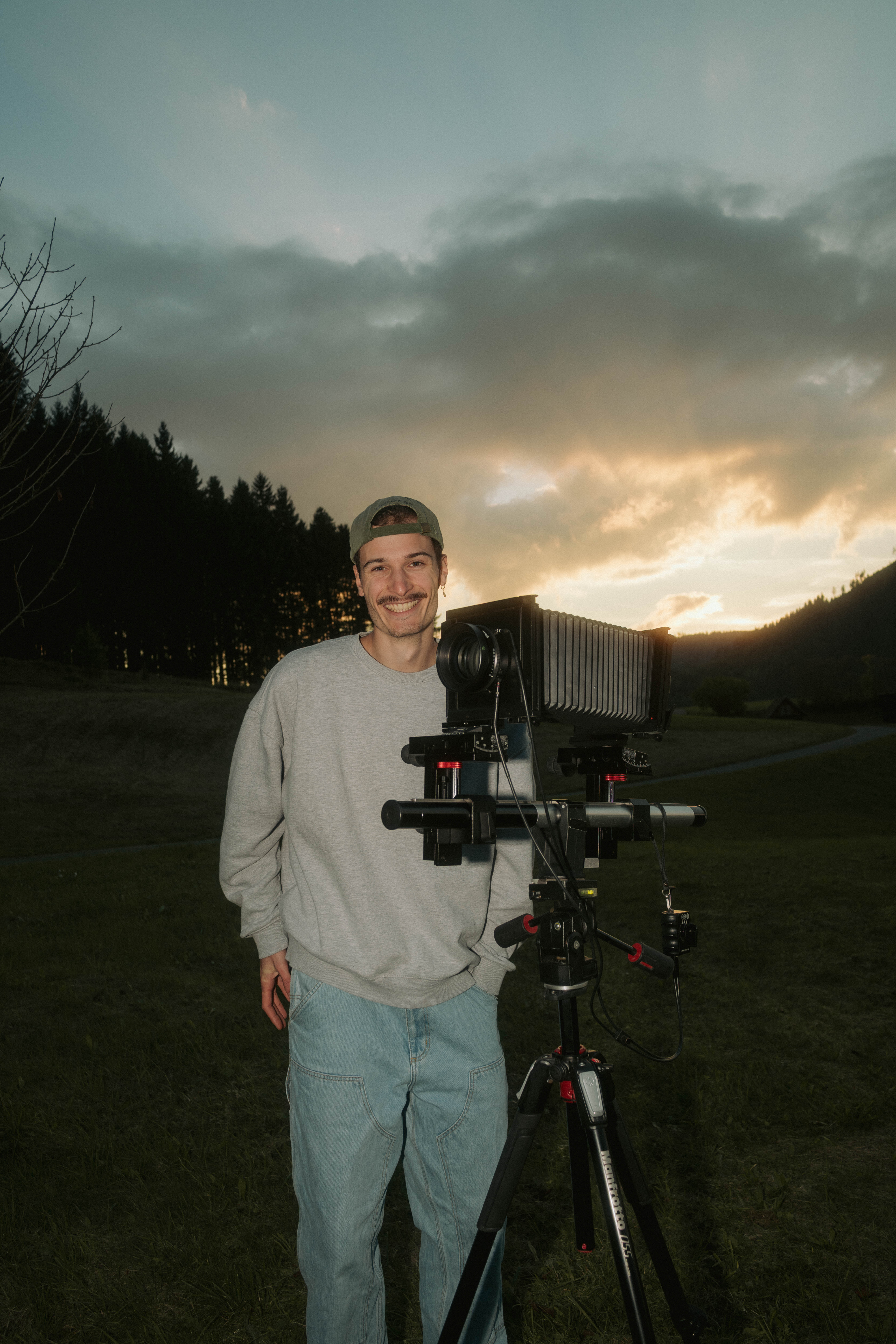 Luis Seybold neben seiner Kamera auf dem Stativ, Abendlicht